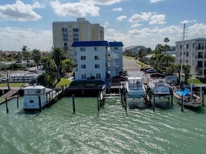 Un puerto deportivo con barcos amarrados, un edificio de varios pisos y un cielo despejado.