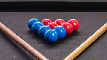 A pool table with a set of billiard balls and two wooden sticks.