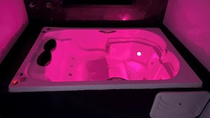 Un jacuzzi con un panel de control y un pequeño ventanal encima.