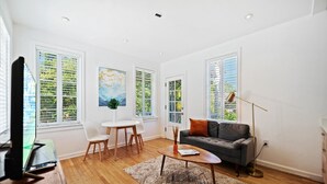 Un salon moderne avec un canapé, une table basse et un coin repas.