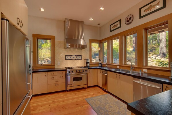 Enjoy cooking in this well-equipped kitchen with a central island, stove, and oven, offering a view of the outdoors.