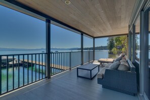 A spacious balcony with a view of the sea, a wooden ceiling, and a seating area with cushions. - Private Pier & Unmatched Lake Views (Bellissimo) (Tahoe Vista)
