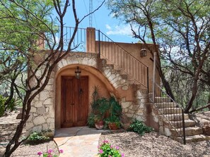A stone archway leading to a wooden door, a stone staircase, and potted plants. - Hotel Centenario Los Arroyitos (Ezequiel Montes)