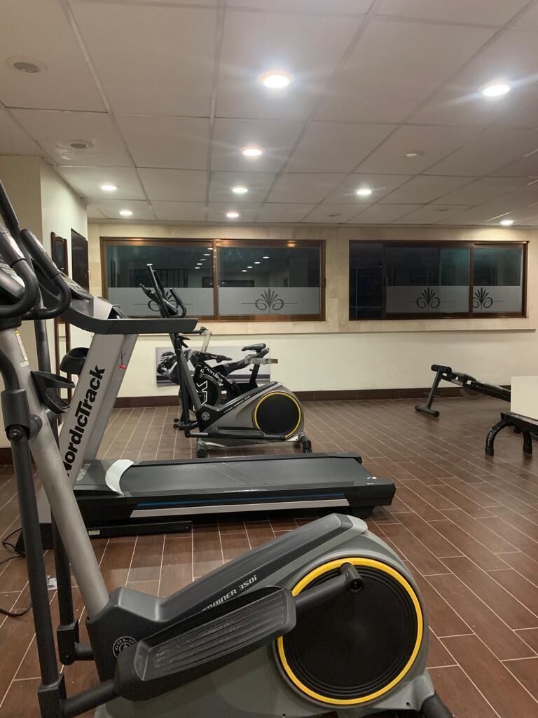 Et fitnesscenter med løbebånd, spinningcykler og træningsudstyr.