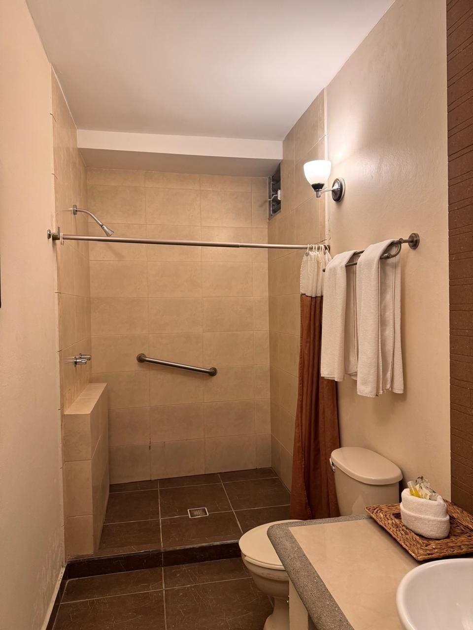 A bathroom with a shower, toilet, and sink.