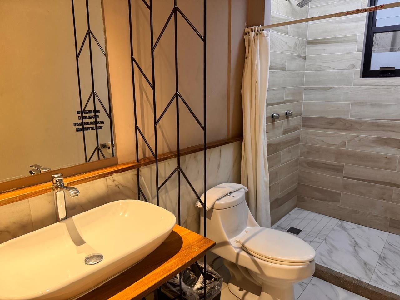 A bathroom with a white sink, toilet, and shower area.