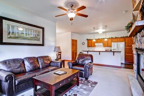 A living room with a leather sofa, a coffee table, and a ceiling fan. - Black Canyon Inn Unit F2 (Estes Park)