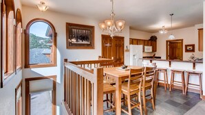 A spacious kitchen with wooden furniture, a dining area with a view, and a large window. - Black Canyon Inn Unit F4 (Estes Park)