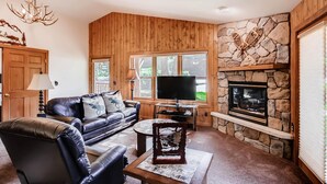 A cozy living room with a fireplace, leather sofa, and a television. - Black Canyon Inn Unit B4/5 (Estes Park)