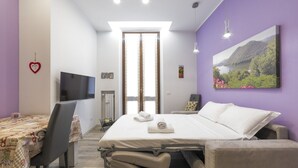 Ein Schlafzimmer mit Bett, Fernseher, Schreibtisch und Stuhl.