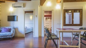 A spacious living area with a sofa, a dining table, and a TV mounted on the wall. - San Cipriano. Apartment with garage included (Toledo)