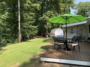 Enjoy al fresco dining on the patio with a shaded table and comfortable seating.