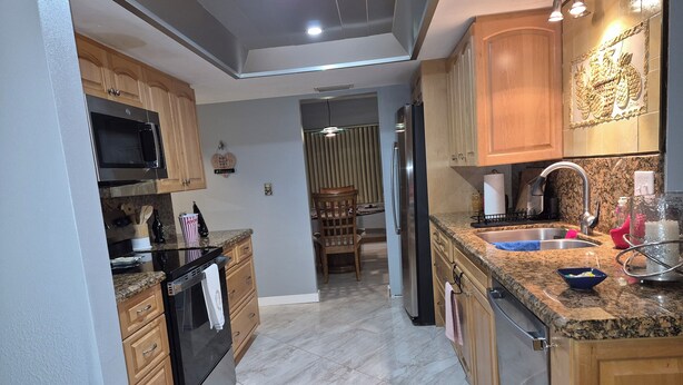 A modern kitchen with granite countertops, stainless steel appliances, and wooden cabinetry. - Amazing house, 2 blocks from the beach (#1 in USA), close to the village.  (Siesta Key)