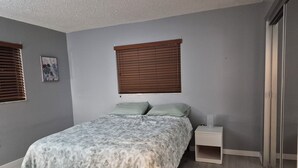A bedroom with a bed, two nightstands, a window with blinds, and a picture on the wall. - Amazing house, 2 blocks from the beach (#1 in USA), close to the village.  (Siesta Key)