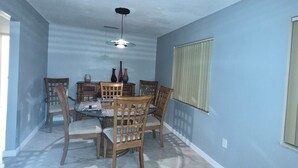 A dining area with a marble floor, wooden chairs, a glass-top table, and a ceiling fan. - Amazing house, 2 blocks from the beach (#1 in USA), close to the village.  (Siesta Key)