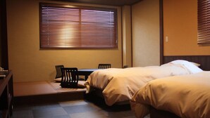 A hotel room with a bed, a small table, and a chair. - Tokiwa Ryokan (Nikko)