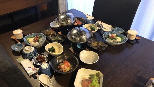 A dining table with various dishes, bowls, and utensils. - Tokiwa Ryokan (Nikko)