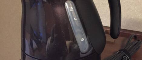 A black T-fal Justine+ electric kettle with a handle and a power cord.