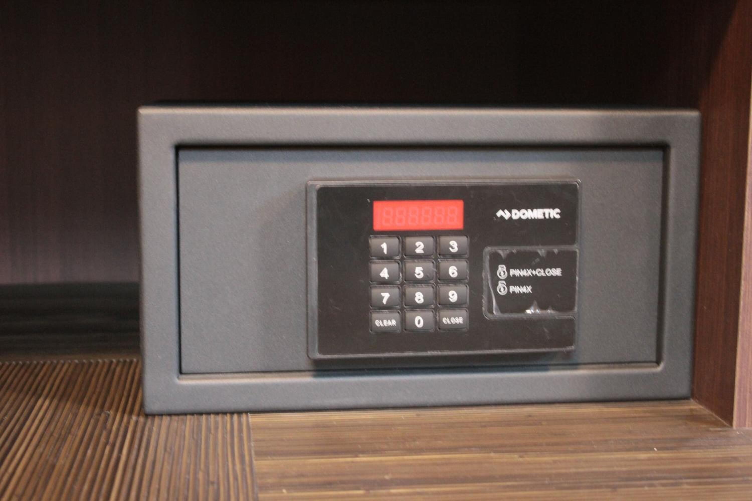 Panel de control de seguridad negro con pantalla roja, que muestra la marca 'DOMETIC', y botones para ingresar el PIN y 'PINX-CLOSE'.