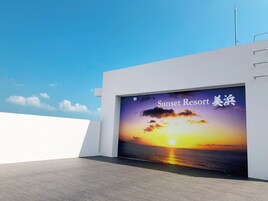 Un edificio moderno con una puerta de garaje grande que muestra una escena de atardecer y el texto