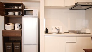 Een kleine keuken met een magnetron, broodrooster en spoelbak.