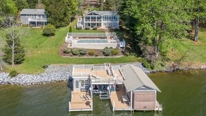 Une propriété au bord du lac, comprenant un quai, une maison et un abri pour bateaux.