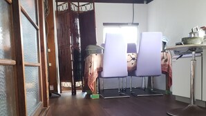 Une pièce avec un plancher en bois, une fenêtre et une table entourée de chaises.