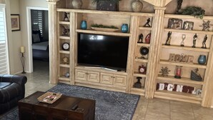 Ein Wohnzimmer mit Kamin, Fernseher und verschiedenen Dekorationselementen.