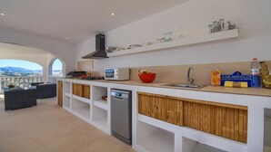 Una cocina moderna con lavavajillas, microondas y un tazón rojo sobre la encimera.