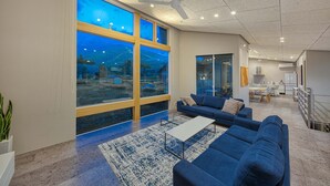 A modern living room with a large window, blue sofas, a coffee table, and a view of a mountainous landscape. - Echo Rocks (Hakuba)