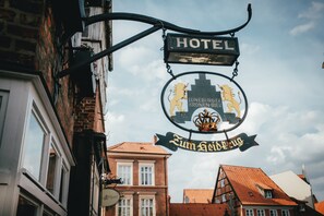 A hotel sign with a lion emblem and the name "Lüneburg Kronen-Bier". - Hotel zum Heidkrug (Lueneburg)