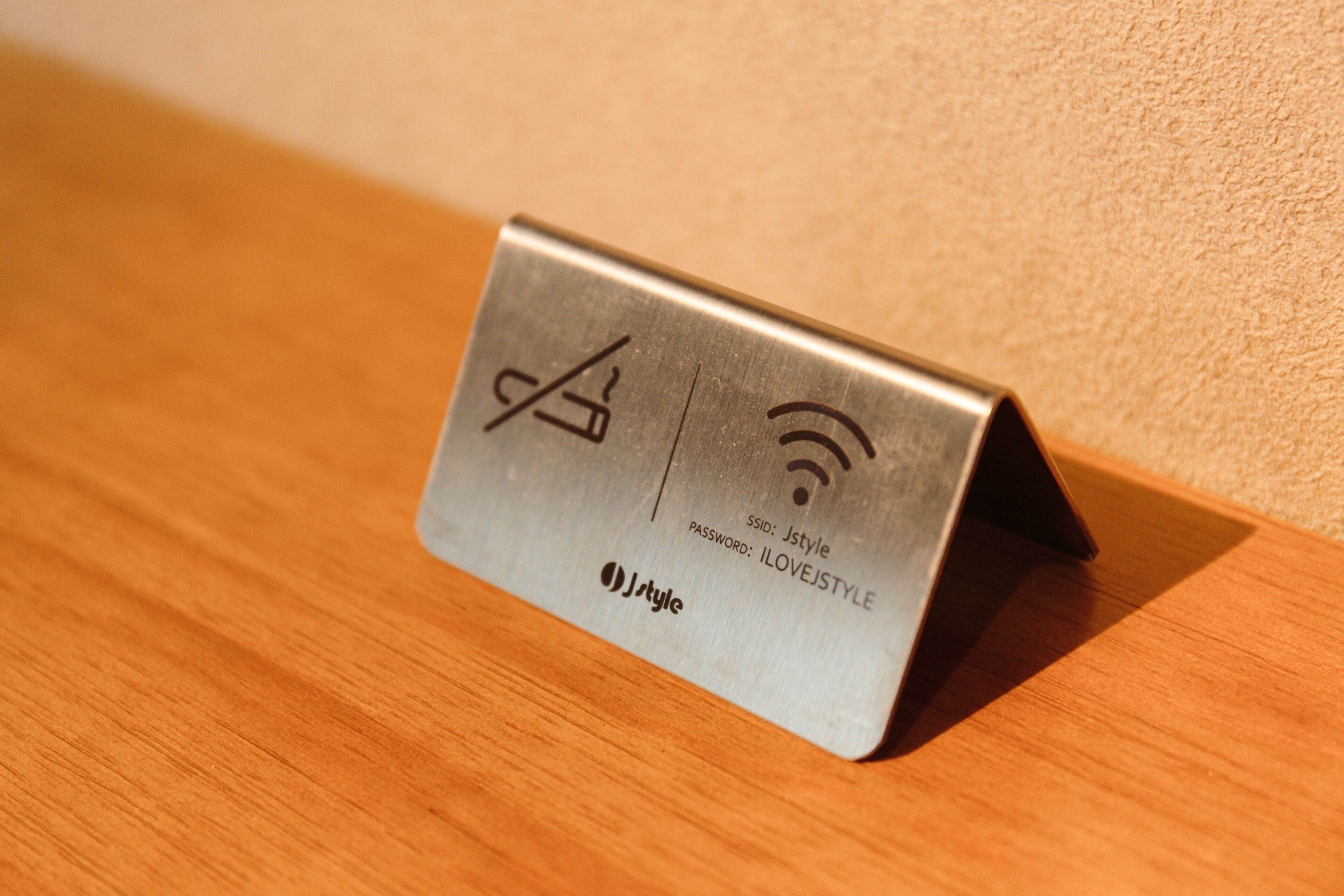 A metallic object with symbols and text, placed on a wooden surface.