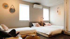 Ein Schlafzimmer mit zwei Betten, einem kleinen Tisch und einem Stuhl.