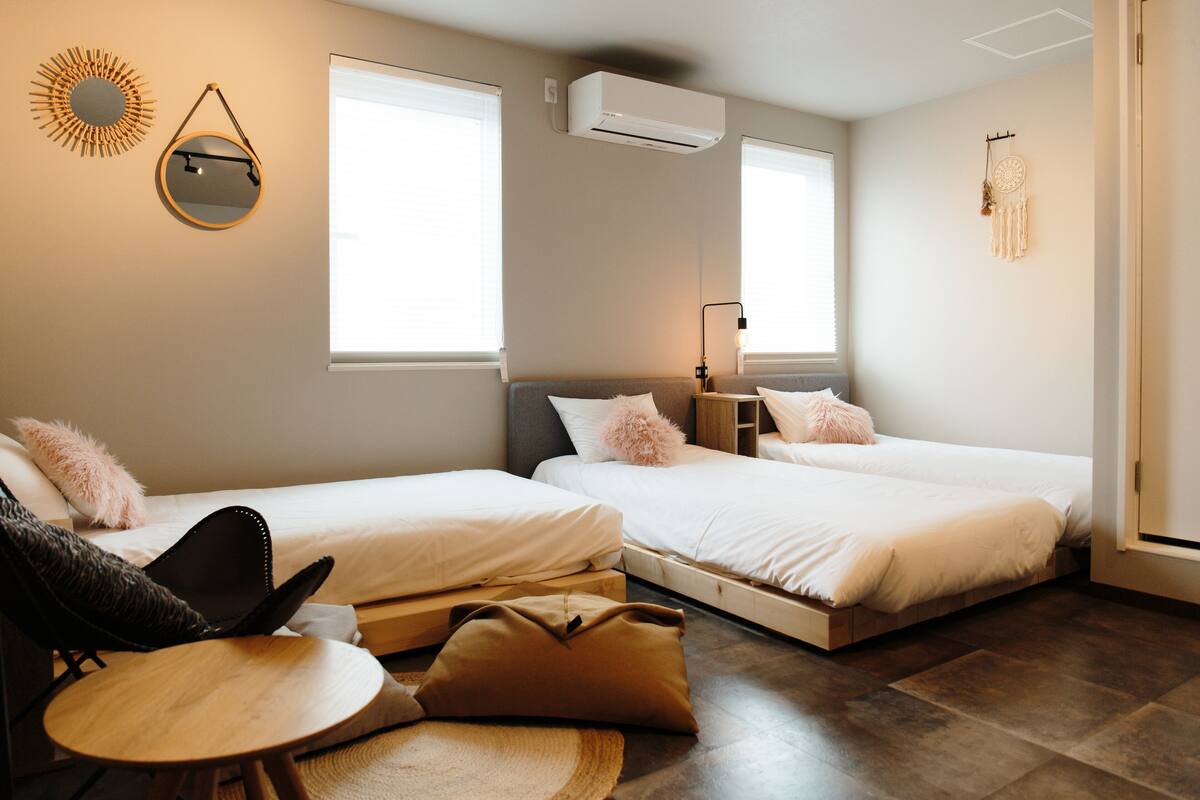 Quarto com duas camas, uma mesinha e uma cadeira.