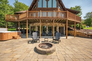 A wooden deck with outdoor seating and a fire pit.