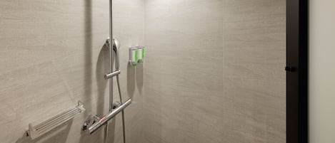 Una ducha moderna con cabezal de ducha de mano, panel de control en la pared y un perchero para toallas.