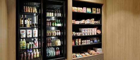 Un refrigerador exhibe bebidas y aperitivos.