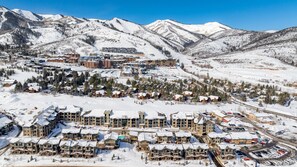 Una località turistica innevata con diversi edifici, tra cui un albergo e una seggiovia.