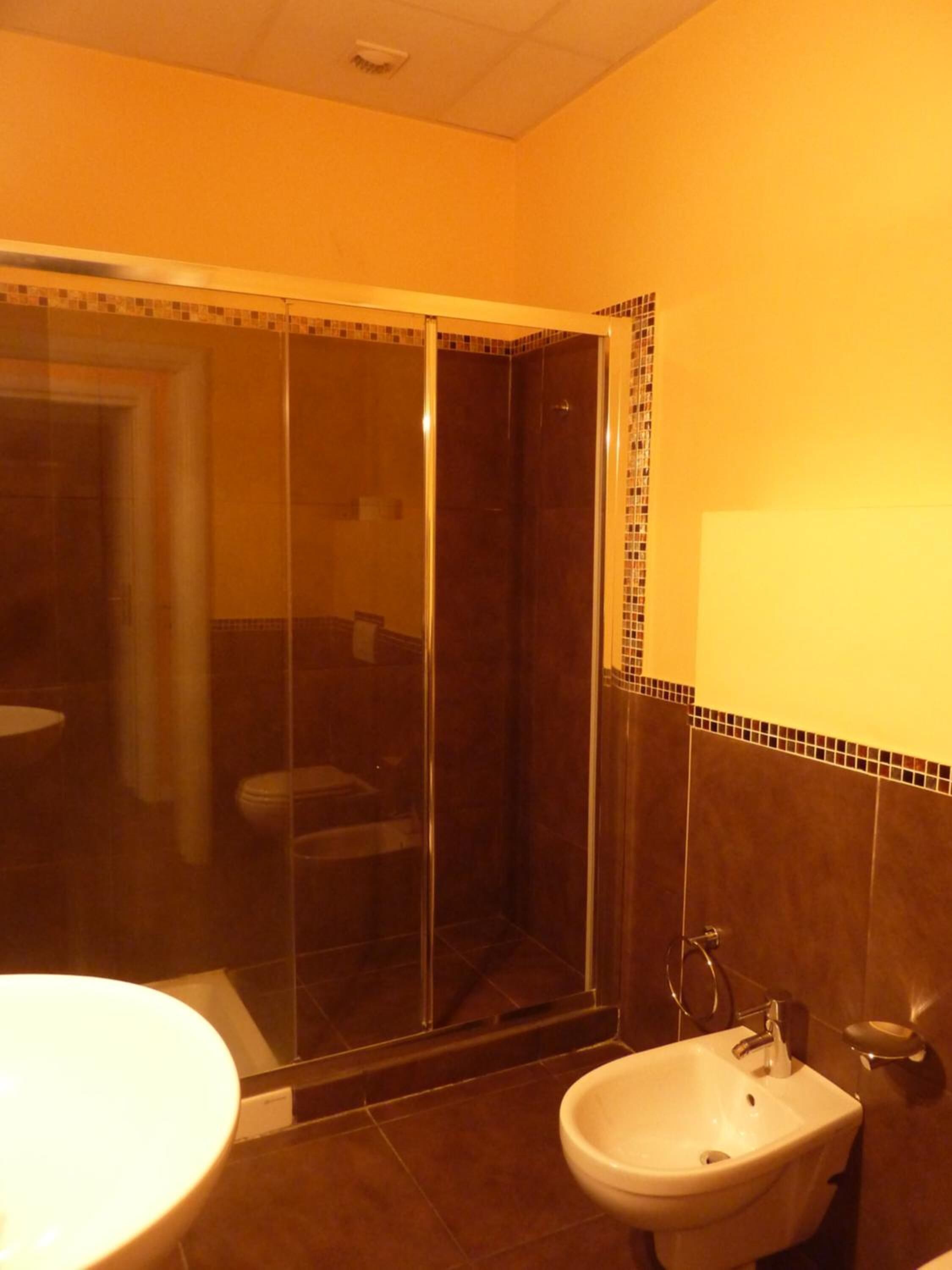 Une salle de bain avec une douche à parois de verre, un lavabo et des toilettes.