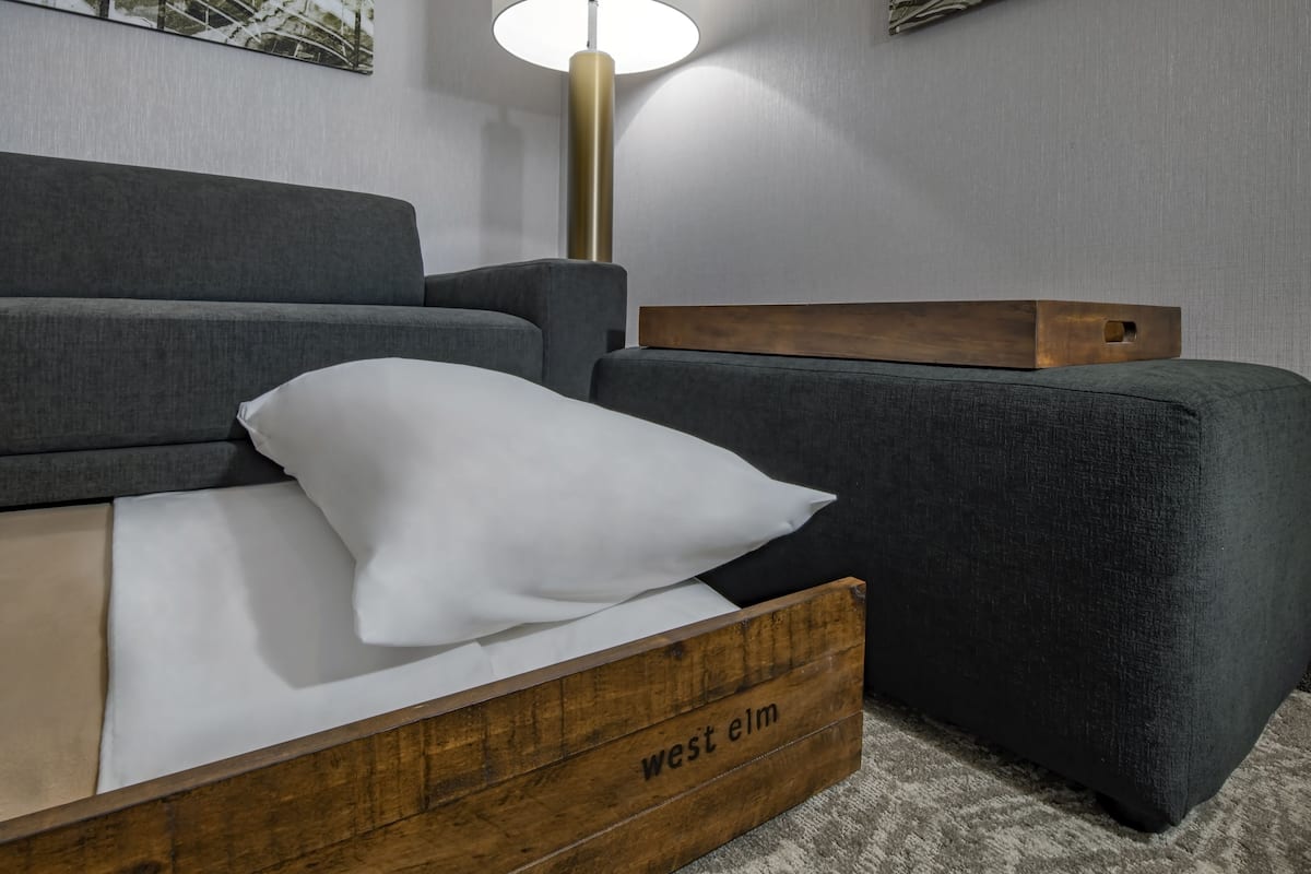 Escritorio, tabla de planchar con plancha y ropa de cama