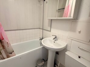 Ein Badezimmer mit Badewanne, Waschbecken und Spiegel.