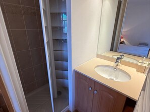 A bathroom with a shower, a sink, and a mirror. - 3-room luxury apartment at the foot of the slopes with private parking (Les Adrets-Prapoutel)