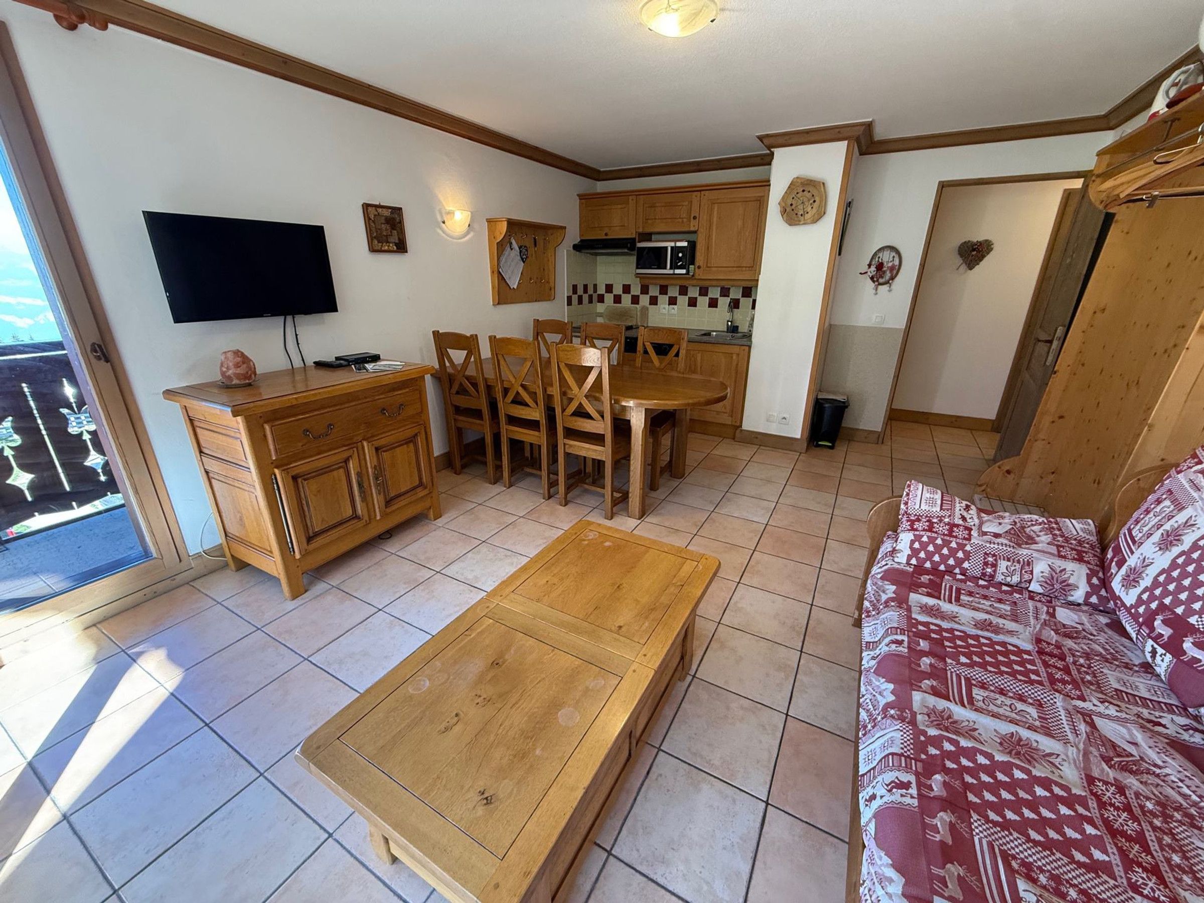A compact living space with a dining area, kitchenette, and a sofa.