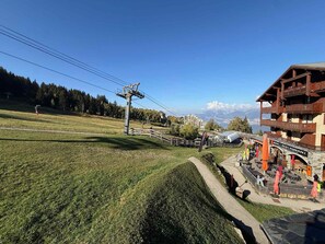 Ein Bergresort mit Seilbahn, Außenbereich zum Sitzen und Blick auf die Berge.