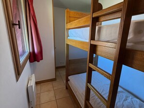 A bunk bed room with a window, a radiator, and a door. - 3-room luxury apartment at the foot of the slopes with private parking (Les Adrets-Prapoutel)