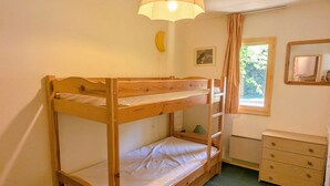 Habitación con literas, un tocador y una lámpara.