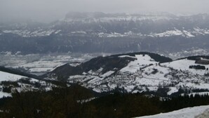 Een panoramisch uitzicht op een berglandschap met besneeuwde toppen en valleien.