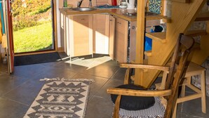 Une cuisine moderne avec des meubles en bois, une cuisinière encastrée et une vue sur l’extérieur.