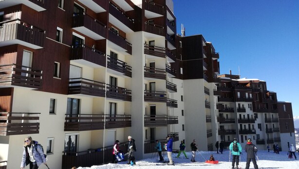 A multi-story building with balconies, likely a hotel or apartment complex.