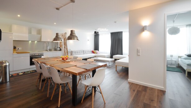 A modern kitchen with a dining area, a sofa, and a bed. - 3 Bathroom - Rhapsody In Roof - Penthouse (München)